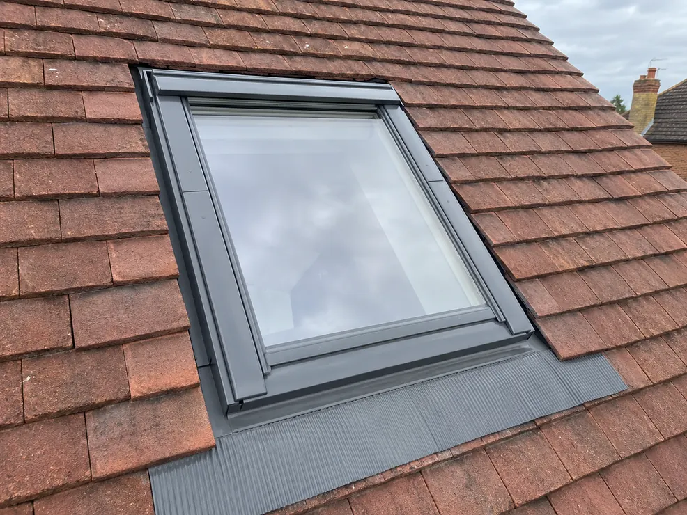 New roof window installed with neat tile and flashing detail